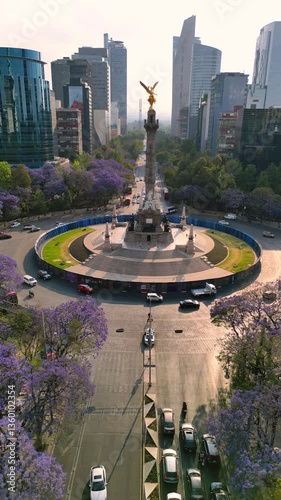 Mexico city Angel de la independencia landmark in downtown, spring with purple flowers jacarandas in paseo de la reforma av