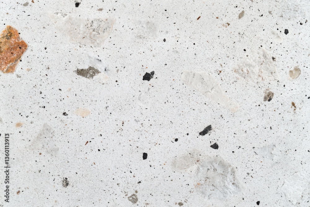 A white rough concrete surface with embedded stones A white rough concrete surface with embedded stones