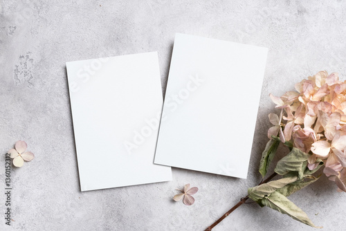Two sides wedding invitation or greeting card mockup with dried hydrangea flowers decor on grey concrete background, copy space