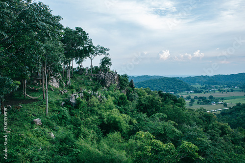 Phusab Lek : LOPBURI, THAILAND, Rolling Hills of Nature: An expansive landscape view showcases a verdant rolling hill under a soft cloudy sky.