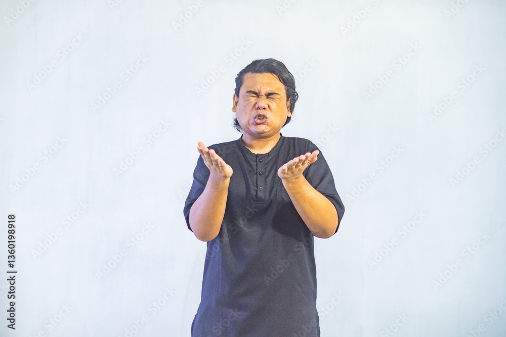 Asian Muslim men pointing to the copy space beside her, isolated by white background. Ramadan and Eid Mubarak concept.