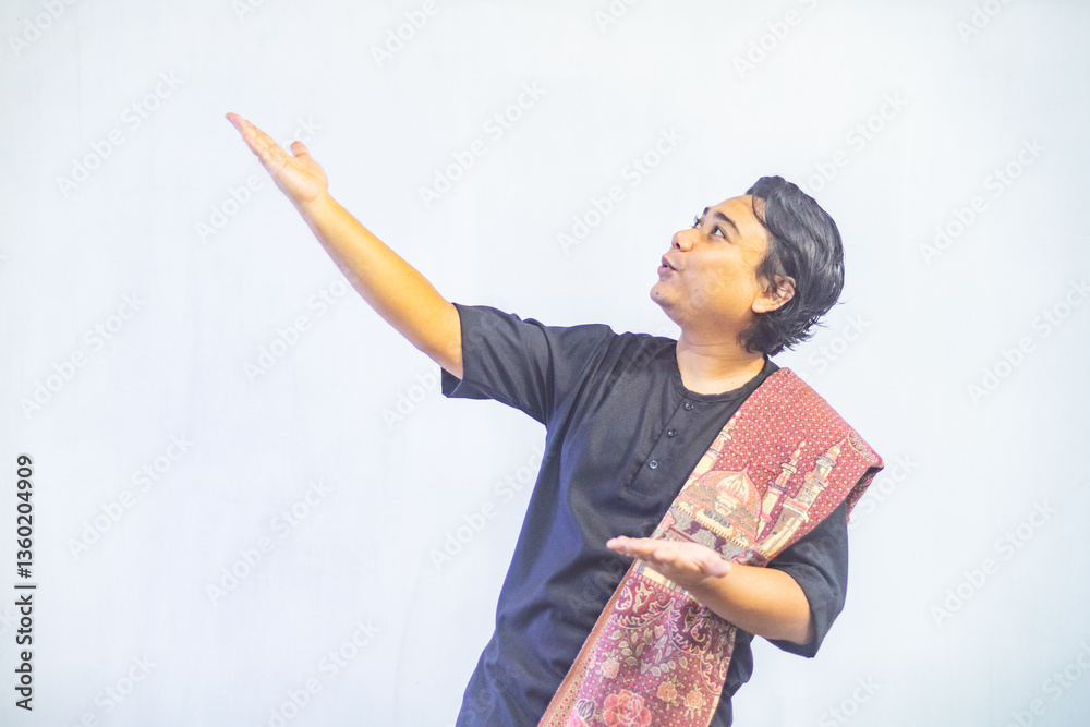 Asian Muslim men pointing to the copy space beside her, isolated by white background. Ramadan and Eid Mubarak concept.