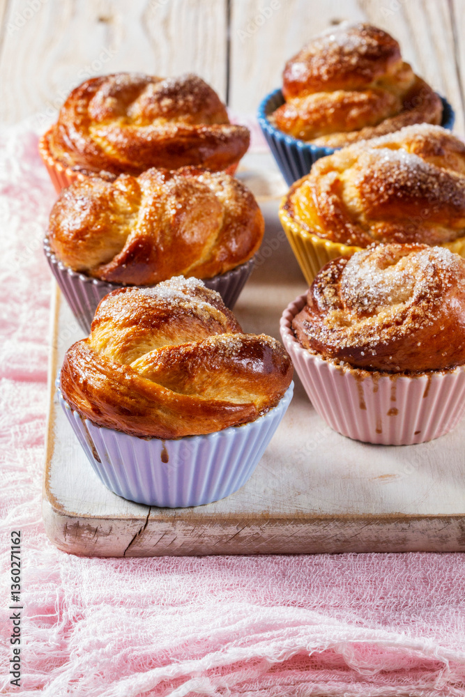 Rose-shaped yeast dough buns sprinkled with sugar in ceramic molds.
