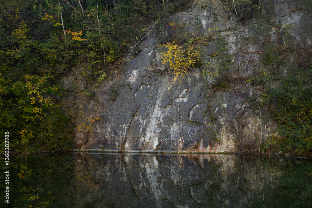 Autumn forest lake. Autumn lake in autumn forest. The autumn foliage of the trees is reflected in the lake water. High quality photo