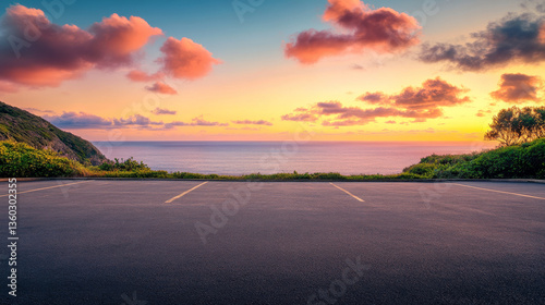 A scenic outdoor asphalt parking lot overlooking a breathtaking coastline and a sky filled with vibrant sunrise colors