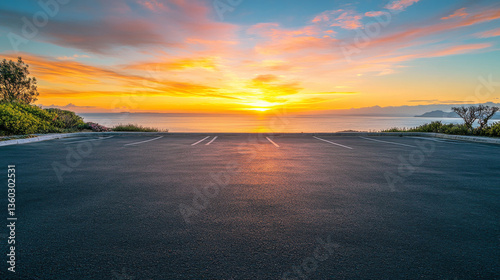 A scenic outdoor asphalt parking lot overlooking a breathtaking coastline and a sky filled with vibrant sunrise colors
