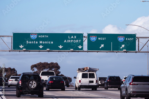 Slow traffic driving below freeway signs on the San Diego 405 freeway near LAX and the 105 freeway interchange in Los Angeles.  