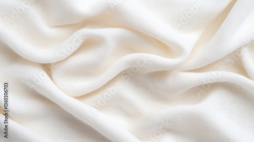 Smooth, flowing, creamy white fabric drapes in soft folds.  A close-up view of the texture