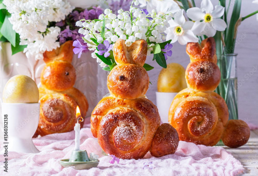 Easter composition made of rabbits, painted eggs and spring bouquets.