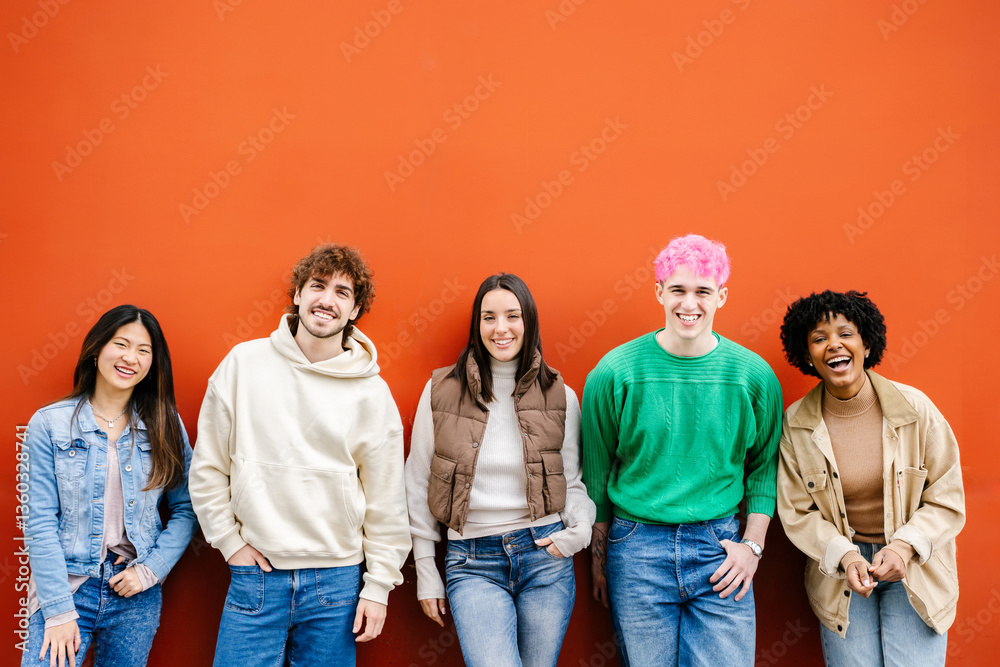 Fototapeta premium Happy multiracial young friends smiling at camera standing over isolated red urban background