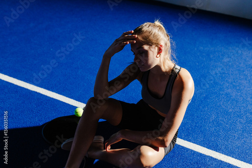 Exhausted athlete resting on court after intense padel tennis match