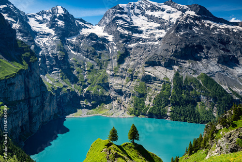 Switzerland travel - Scenic view high above the Oeschinen lake in the Swiss Alps near Kandersteg.  Popular hiking around the turquoise-colored lake with majestic views of waterfalls and the Doldenhorn