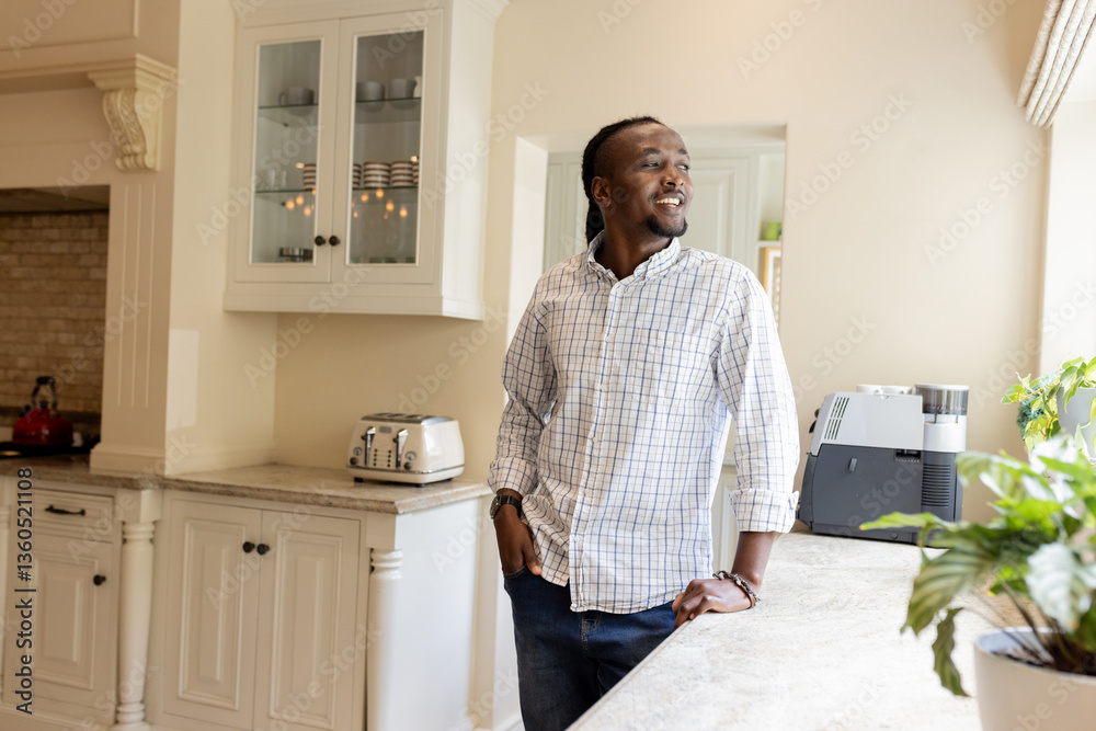 Smiling man standing in kitchen, enjoying morning sunlight and peaceful moment, copy space Smiling man standing in kitchen, enjoying morning sunlight and peaceful moment, copy space