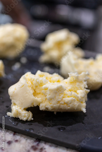 Close-up of fresh homemade butter on black cutting board