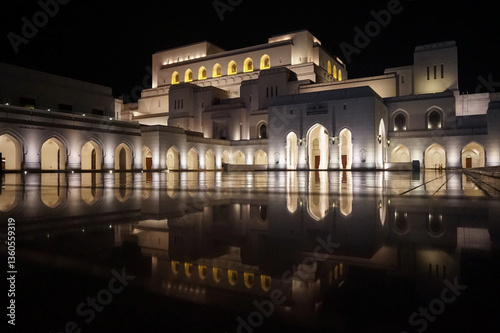 Majestic Illuminated Exterior of the Royal Opera House Muscat, Oman at Night with Reflections in Water, Showcasing Arabian Architecture and Cultural Heritage