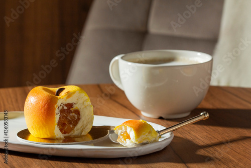 Obraz na płótnie Mousse cake with peach filling covered with velvet glaze and a cup of latte on a table in a cafe. w salonie