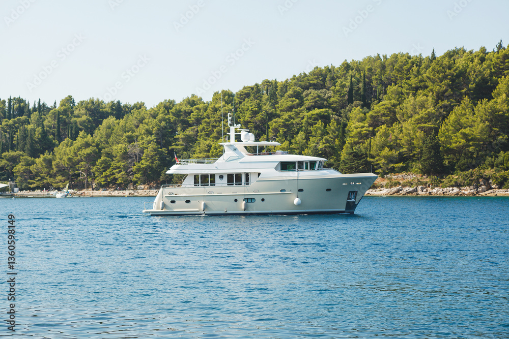 A luxurious yacht sails through scenic ocean waters, offering an unforgettable experience