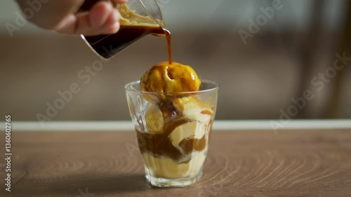 classic Italian Affogato of hand pouring espresso into vanilla ice cream, blending bitter and sweet flavors into a creamy aromatic dessert drink.