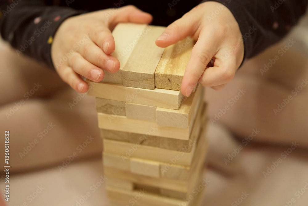 Child Building Wooden Block Tower with Focused Hands Child Building Wooden Block Tower with Focused Hands