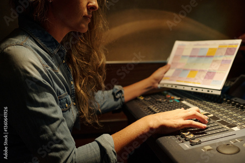 Fotografia Cropped shot of young female journalist with broadcast schedule in hand adjustin