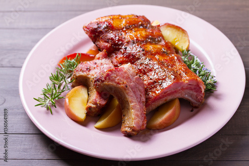 Barbecue grilled pork ribs with apples and rosemary on a plate