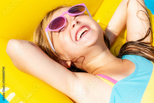 Obraz na płótnie Top view little girl lying on inflatable mattress in swimming pool with blue water on warm summer day on tropical vacation. Summertime activities concept. Cute little girl sunbathing on air mattress w salonie