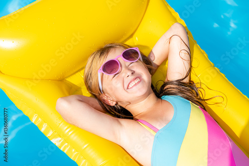 Obraz na płótnie Top view little girl lying on inflatable mattress in swimming pool with blue water on warm summer day on tropical vacation. Summertime activities concept. Cute little girl sunbathing on air mattress w salonie