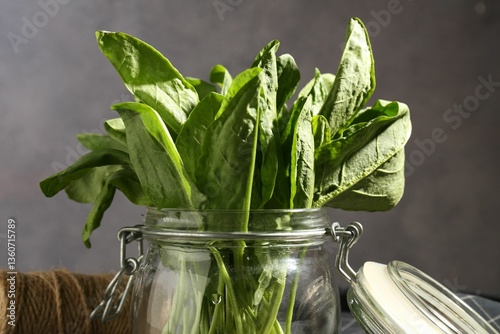 Fotografía Fresh sorrel in glass jar on grey background, closeup