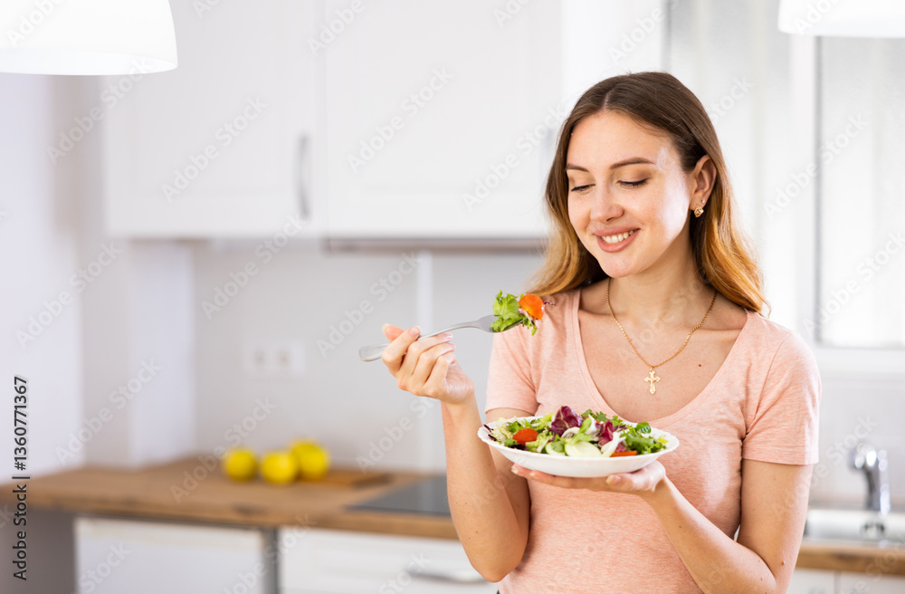 Φωτογραφία Portrait of positive vegeterian woman eating fresh vegetable salad at home