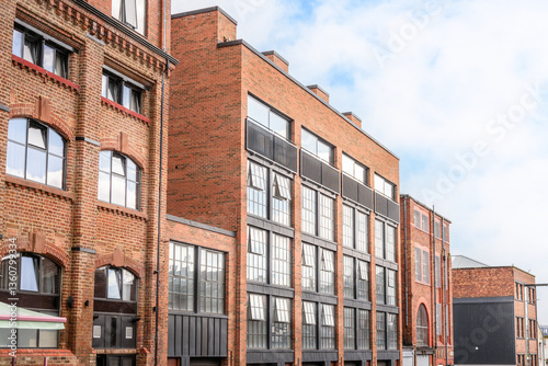 Renovated brick warehouses converted in apartment lofts on a cloudy summer day