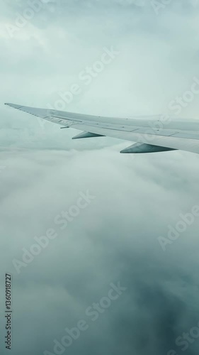 Looking out above clouds from an airplane flying above on an overcast day