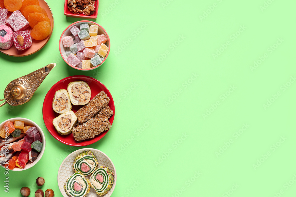 Composition with different Eastern dishes and Aladdin lamp on green background. Ramadan celebration Composition with different Eastern dishes and Aladdin lamp on green background. Ramadan celebration