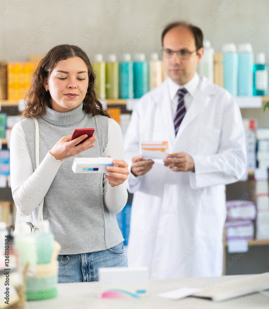 Young woman buyer scanning qr code for ointment with adult man pharmacist in pharmacy Young woman buyer scanning qr code for ointment with adult man pharmacist in pharmacy