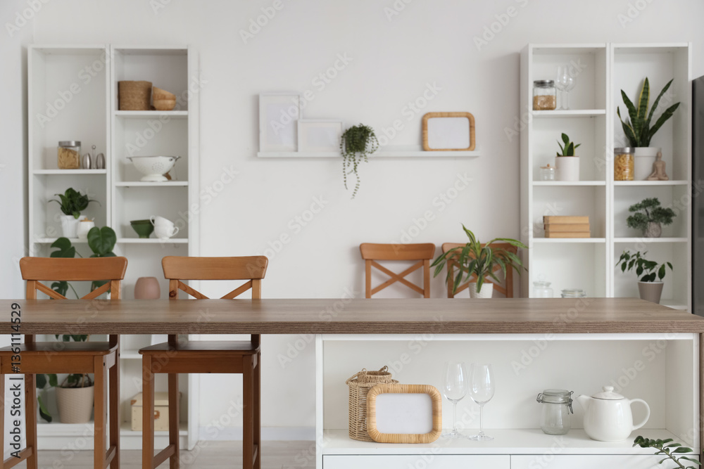 Fototapeta premium Interior of stylish kitchen with island table, houseplants and shelving units