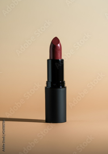 Minimal Studio Shot of Burgundy Lipstick on Beige Background