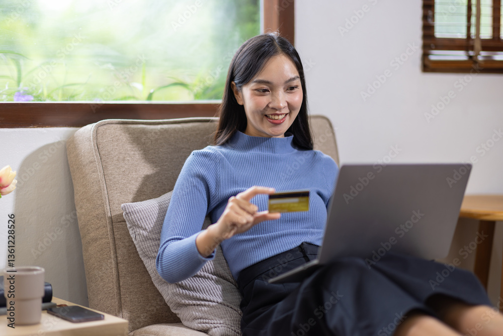 Young Asian woman at home happy doing online shopping on laptop and paying with credit card. Young Asian woman at home happy doing online shopping on laptop and paying with credit card.