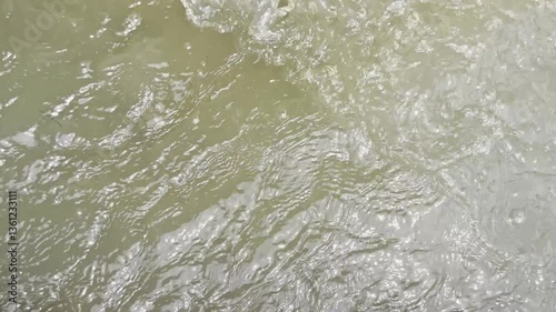 Water flows in the gutter Close-up of a part of an irrigation channel for agriculture