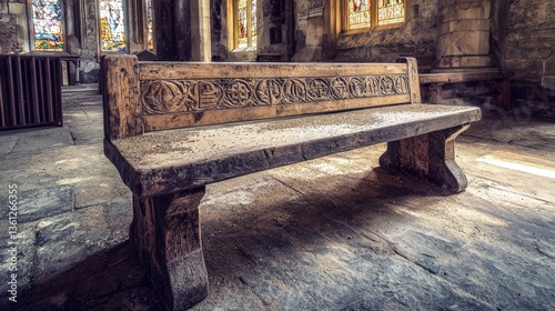 Antique wooden church bench with intricate carvings, inside a historic building with stained-glass windows.  A beautiful example of aged craftsmanship.