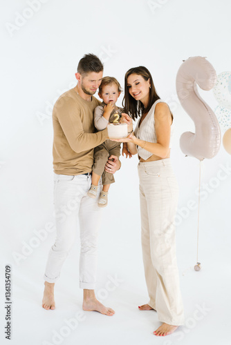 Obraz na płótnie Young couple and their child are posing for a picture in front of a birthday cake w salonie