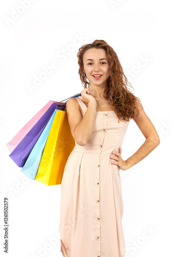Young beautiful girl with curly hair with bags and purchases from the store. Figure isolated on white background.