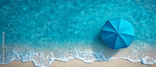 Aerial view of blue beach umbrella on sandy shore with ocean waves