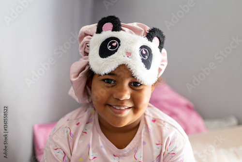 Smiling young girl with eye mask and hair bonnet on