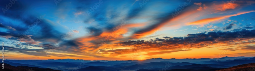 Obraz premium Vivid Sunset Over Mountain Range with Dramatic Sky and Clouds