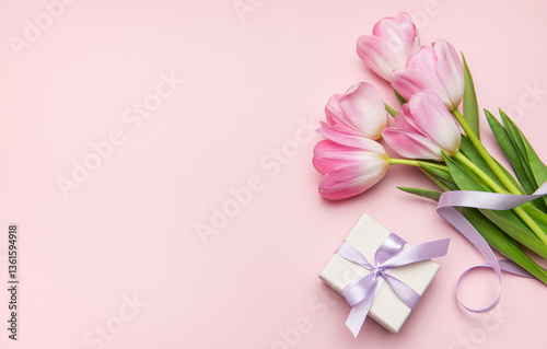 Pink tulips and gift box on pastel pink background for mother's day or birthday