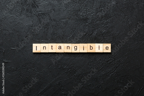 intangible word written on wood block. intangible text on cement table for your desing, concept