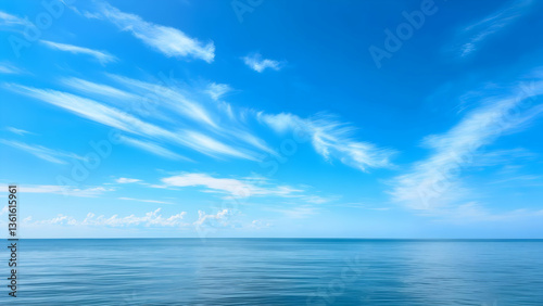 Wallpaper Mural Soft formations of delicate cirrus clouds drift gently across a vast, bright blue sky, overlooking a tranquil ocean expanse reaching towards a clear distant horizon Torontodigital.ca