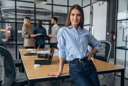 Free Download Cheerful woman is standing. Professional workers are in the modern office together - GFXLoad