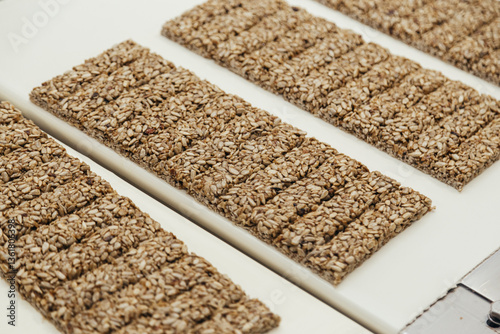 Obraz na płótnie Gozinaki made from sunflower seeds with sugar syrup transferring by conveyor at sweet industry w salonie