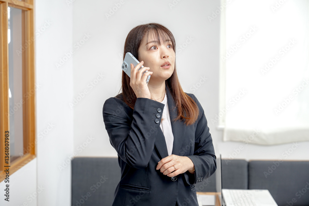 はっとした顔で電話するビジネスウーマン はっとした顔で電話するビジネスウーマン