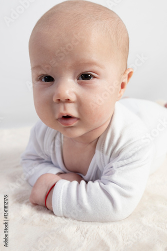 Three-month-old baby lying on a soft blanket